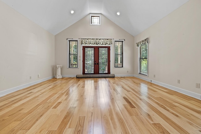 interior space with baseboards, high vaulted ceiling, french doors, and light wood-style floors