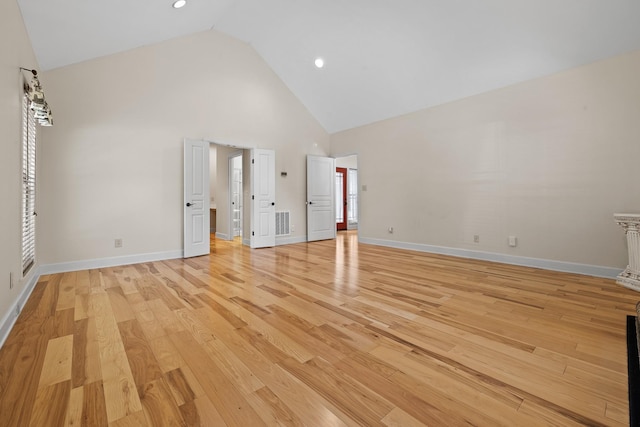 unfurnished bedroom with high vaulted ceiling, light wood finished floors, visible vents, and baseboards
