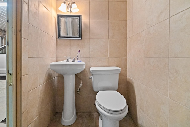 bathroom featuring toilet and tile walls
