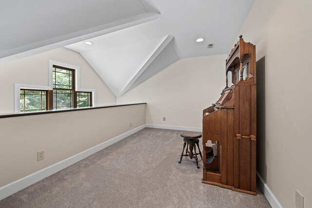 carpeted office featuring lofted ceiling