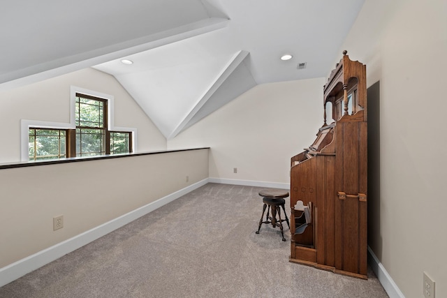 additional living space with lofted ceiling, visible vents, baseboards, and light colored carpet