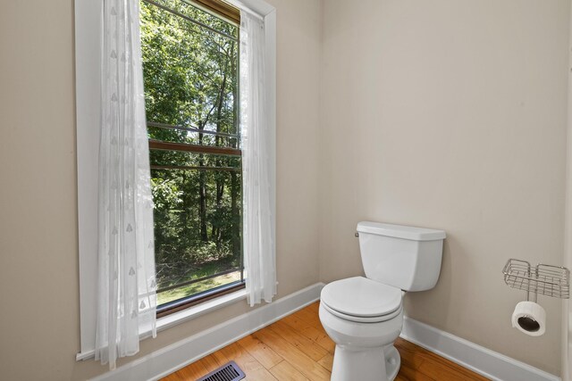 bathroom with hardwood / wood-style floors and toilet