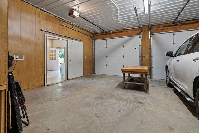 garage featuring a garage door opener and metal wall