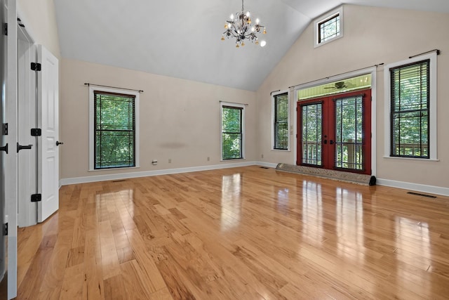 foyer with french doors, visible vents, light wood-style flooring, an inviting chandelier, and high vaulted ceiling
