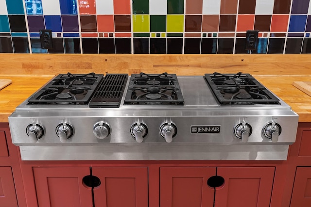 interior details with stainless steel gas cooktop, wooden counters, and decorative backsplash