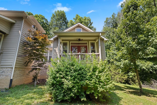 view of front facade with french doors, a front lawn, and brick siding