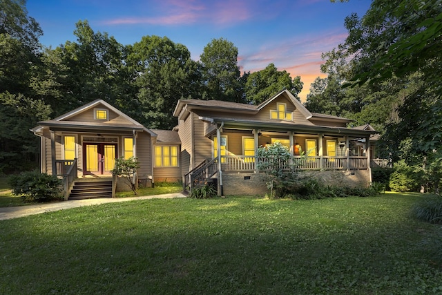 view of front of property featuring covered porch and a yard