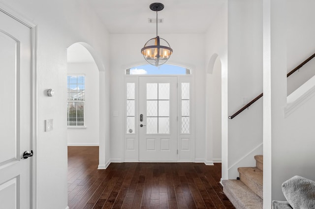 foyer with dark hardwood / wood-style floors and a notable chandelier