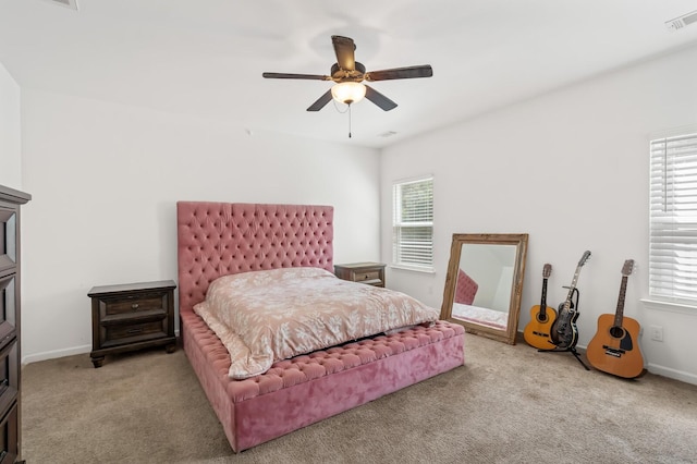 carpeted bedroom with multiple windows and ceiling fan