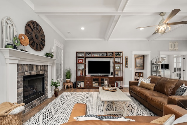 living room featuring ceiling fan, hardwood / wood-style floors, ornamental molding, and beamed ceiling