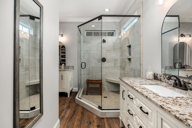 bathroom featuring hardwood / wood-style flooring, a shower with door, and vanity