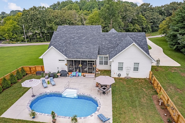 view of swimming pool featuring a lawn, a sunroom, and a patio