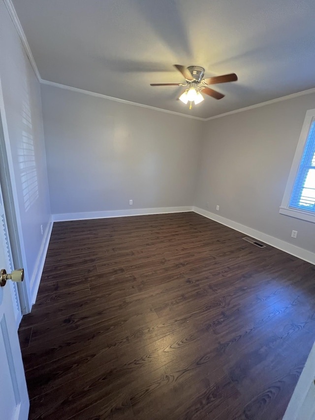 empty room with visible vents, baseboards, a ceiling fan, ornamental molding, and dark wood-style floors