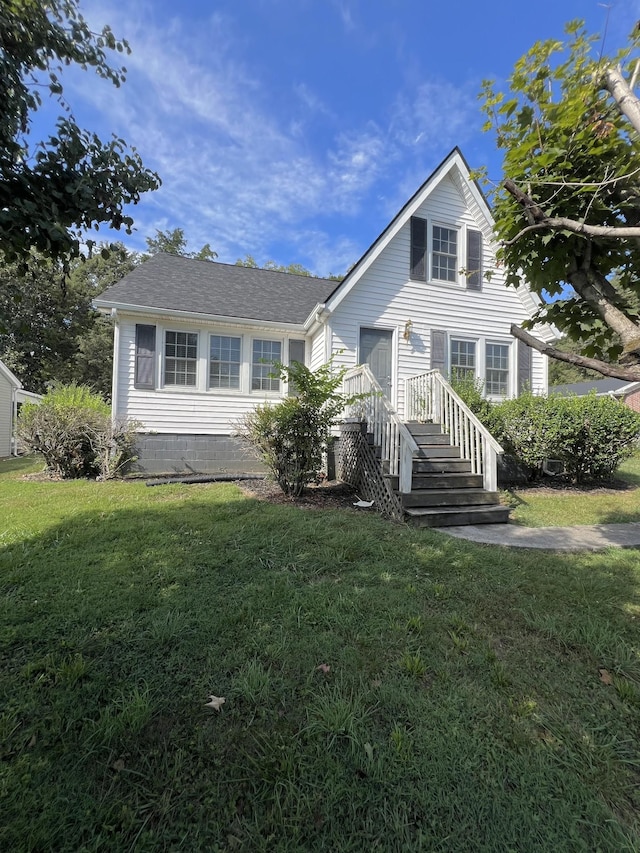 view of front of home featuring a front lawn and roof with shingles