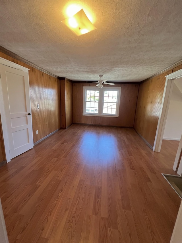 spare room featuring baseboards, a textured ceiling, a ceiling fan, and wood finished floors