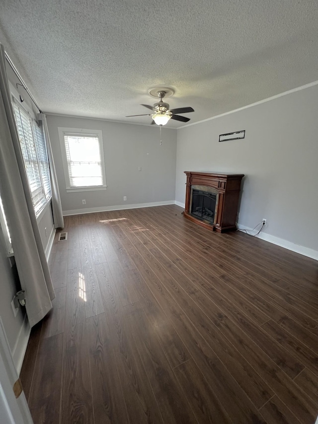 unfurnished living room featuring ceiling fan, a fireplace, visible vents, baseboards, and dark wood-style floors