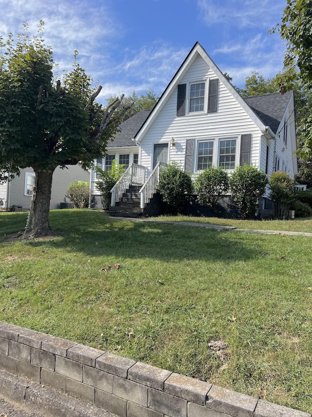 view of front of home featuring a shingled roof and a front lawn