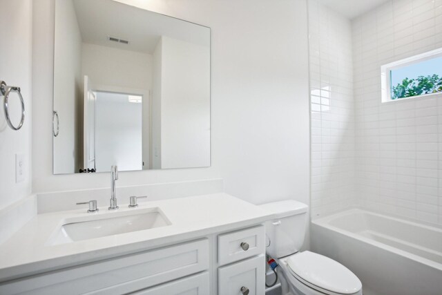 full bathroom featuring toilet, tiled shower / bath combo, and vanity