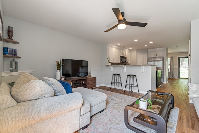 living room featuring ceiling fan and light wood-type flooring