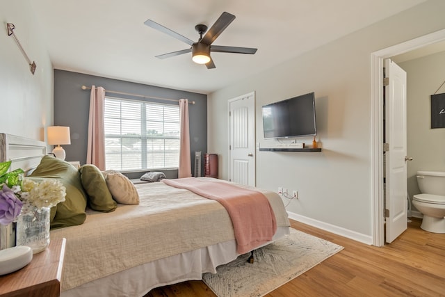 bedroom with ceiling fan, ensuite bath, and light hardwood / wood-style flooring