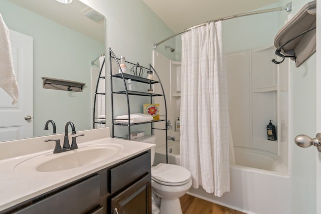 full bathroom featuring hardwood / wood-style floors, shower / bath combo, toilet, and vanity