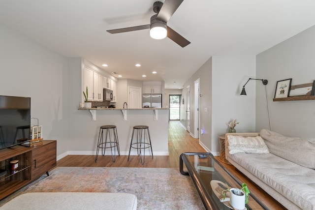 living room featuring light wood-type flooring and ceiling fan