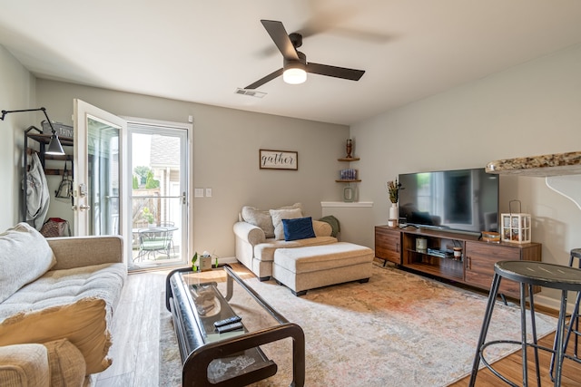 living room with light hardwood / wood-style floors and ceiling fan