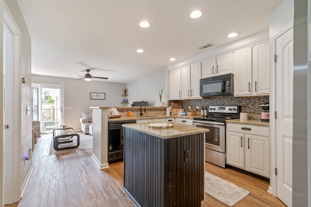 kitchen featuring light hardwood / wood-style flooring, light stone counters, black appliances, white cabinets, and ceiling fan