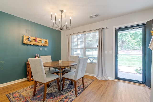 dining area featuring a wealth of natural light, a chandelier, and light wood-type flooring