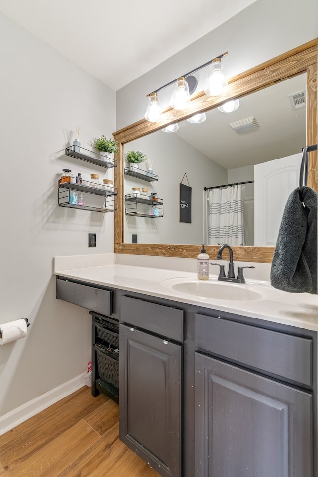 bathroom with hardwood / wood-style floors, a shower with shower curtain, and vanity