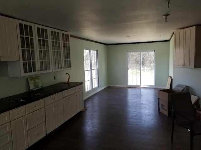 kitchen featuring dark wood-type flooring, ornamental molding, and white cabinets