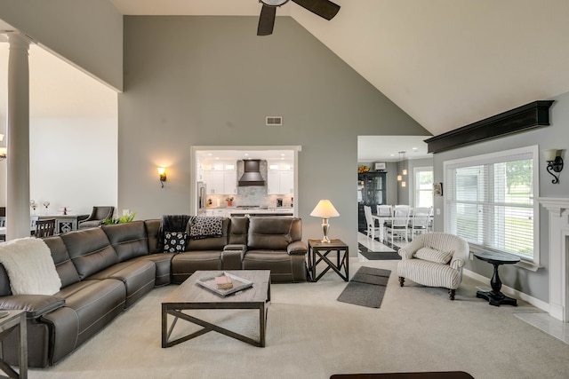 living room featuring light colored carpet, high vaulted ceiling, and ceiling fan