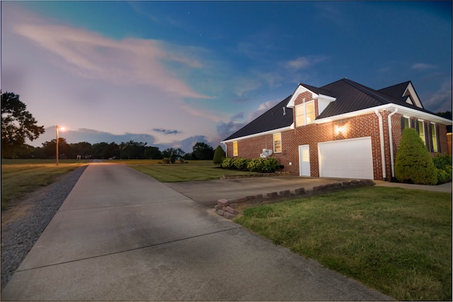 property exterior at dusk featuring a garage and a lawn