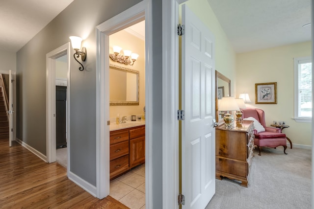 hall with sink and light carpet