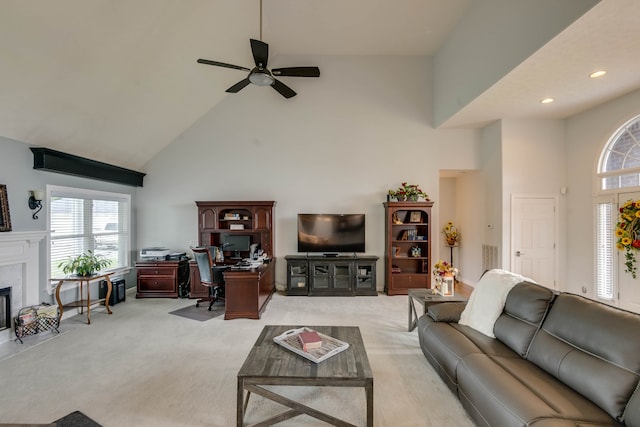 carpeted living room with ceiling fan and high vaulted ceiling