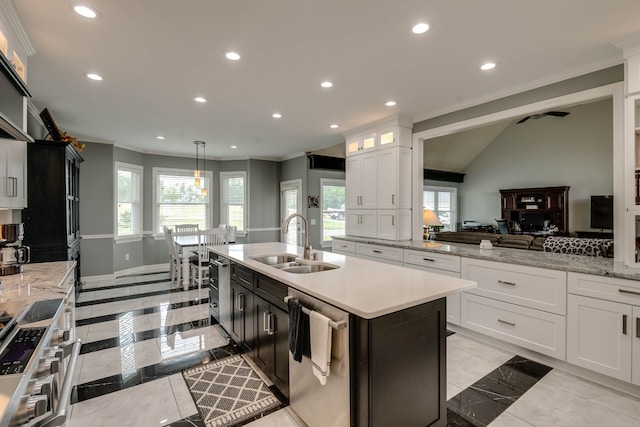 kitchen with a wealth of natural light, appliances with stainless steel finishes, light tile patterned floors, sink, and decorative light fixtures