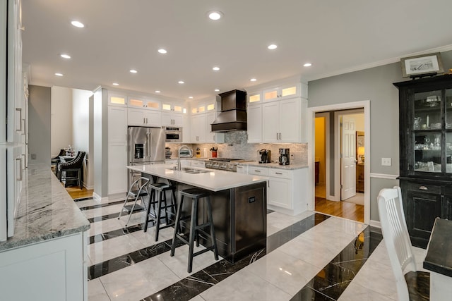 kitchen with decorative backsplash, an island with sink, light wood-type flooring, high end fridge, and custom exhaust hood