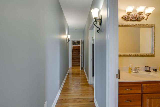 hallway with sink and light hardwood / wood-style flooring