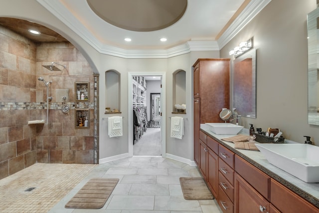 bathroom featuring vanity, tile patterned flooring, crown molding, a raised ceiling, and tiled shower