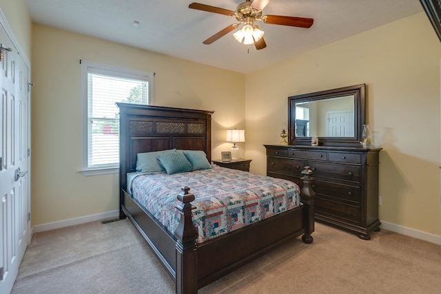 bedroom with a closet, ceiling fan, and light colored carpet