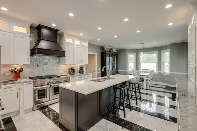 kitchen with backsplash, sink, range with two ovens, premium range hood, and light tile patterned floors