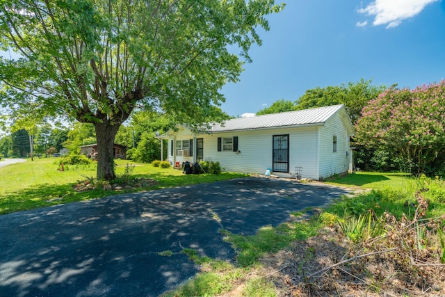 ranch-style house with a front yard, aphalt driveway, and metal roof