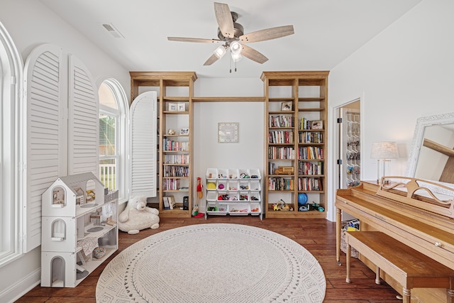 living area featuring ceiling fan and dark hardwood / wood-style flooring