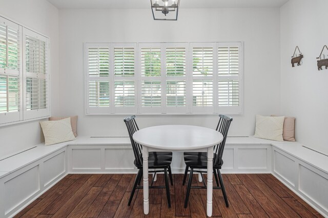 dining area with a notable chandelier, breakfast area, and dark hardwood / wood-style flooring