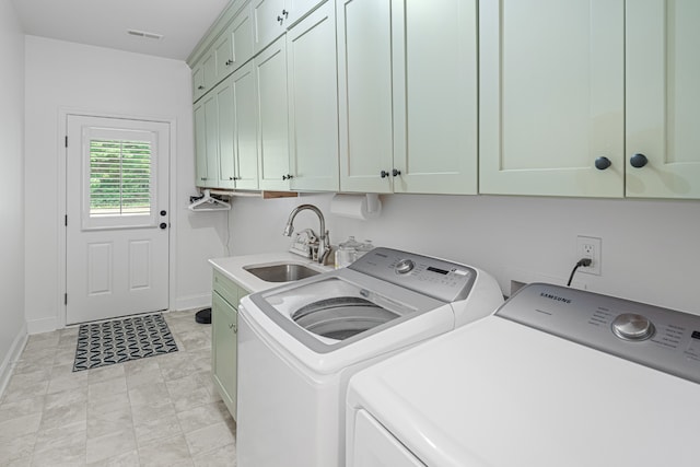 washroom featuring independent washer and dryer, light tile patterned floors, sink, and cabinets