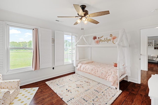 bedroom with ceiling fan, multiple windows, and dark hardwood / wood-style floors