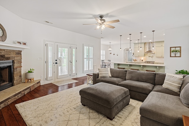 living room with ceiling fan, sink, light hardwood / wood-style flooring, and a fireplace