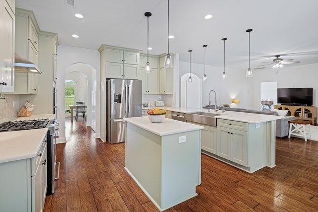 kitchen featuring backsplash, sink, dark hardwood / wood-style flooring, decorative light fixtures, and stainless steel appliances