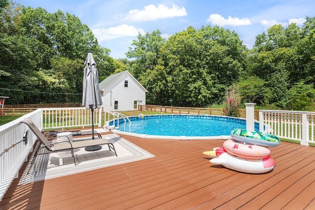 view of pool featuring a wooden deck and an outdoor structure