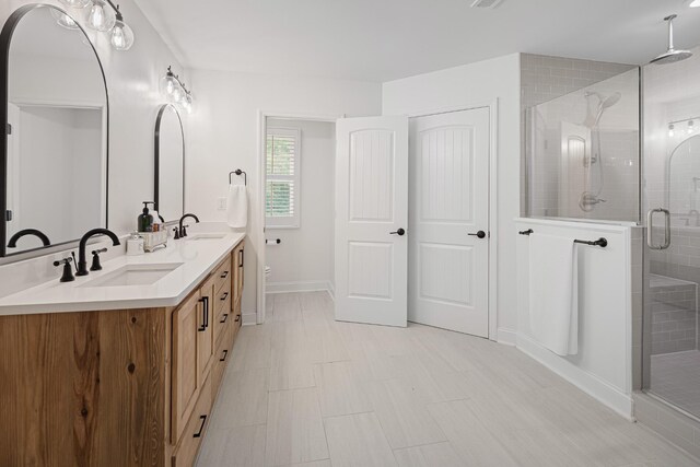 bathroom featuring tile patterned flooring, a shower with door, and vanity